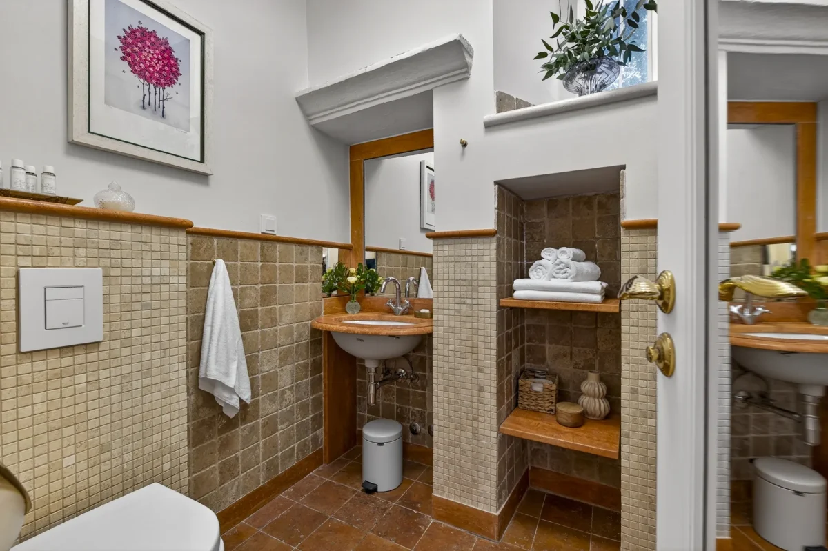 Deluxe Double en-suite bathroom with tiled niche shelves, fresh towels and terracotta floor