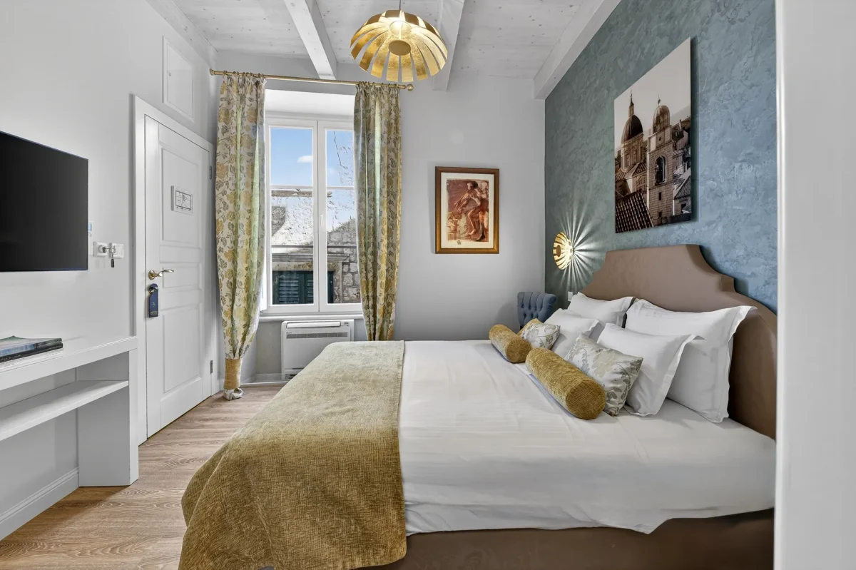 Deluxe Double Room at Dominus Little Palace with wall-mounted TV, writing desk and curtained window