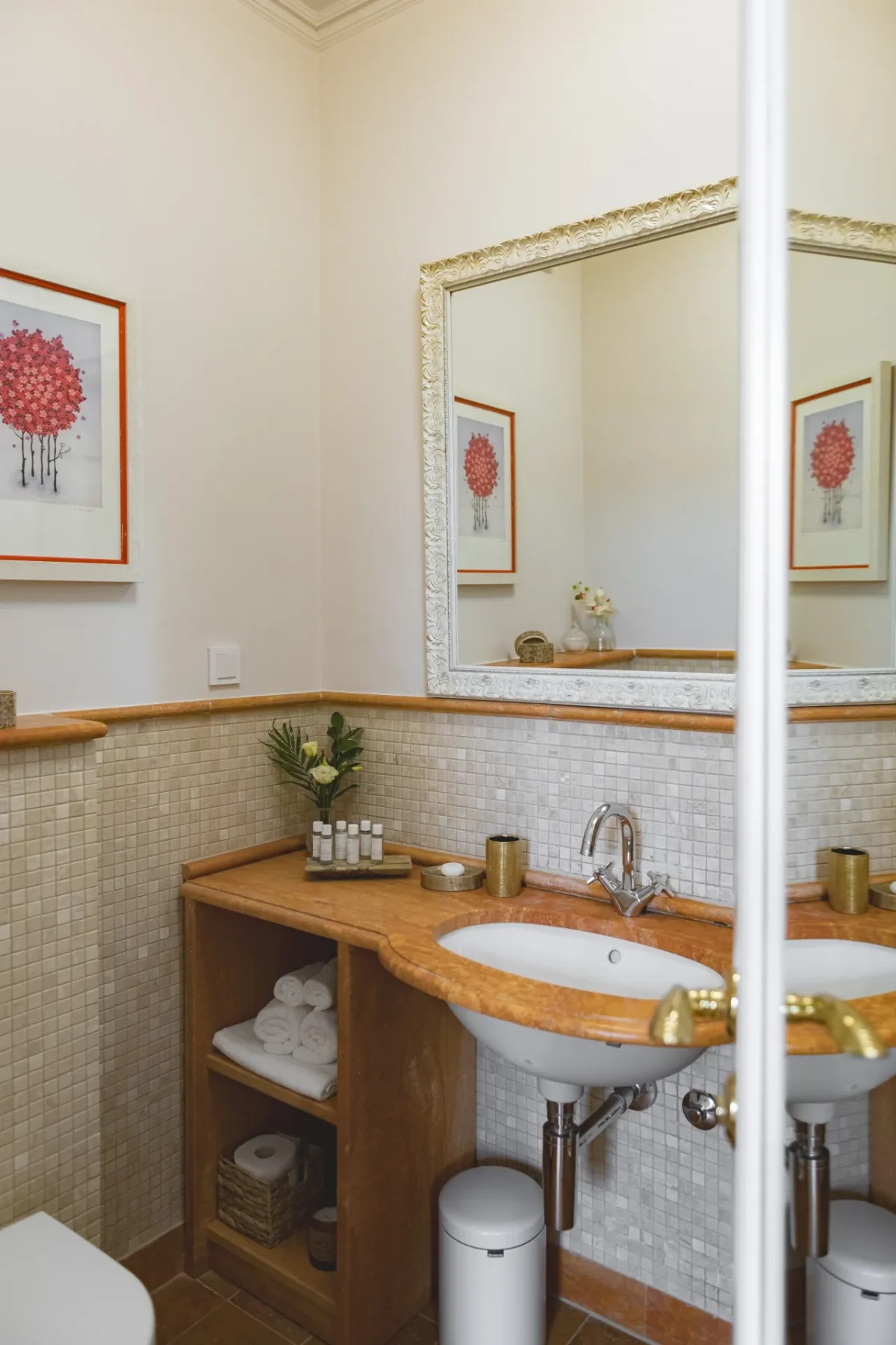 Bathroom vanity with marble countertop, washbasin and guest toiletries seen through the Deluxe Double Room door