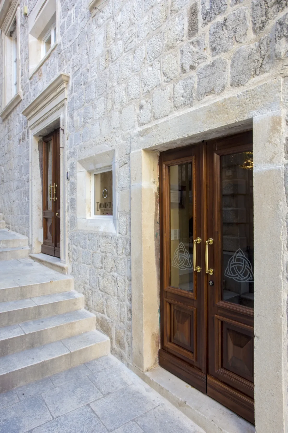 Stone steps and the wooden entrance door of Dominus Little Palace inside the walls of Dubrovnik Old Town