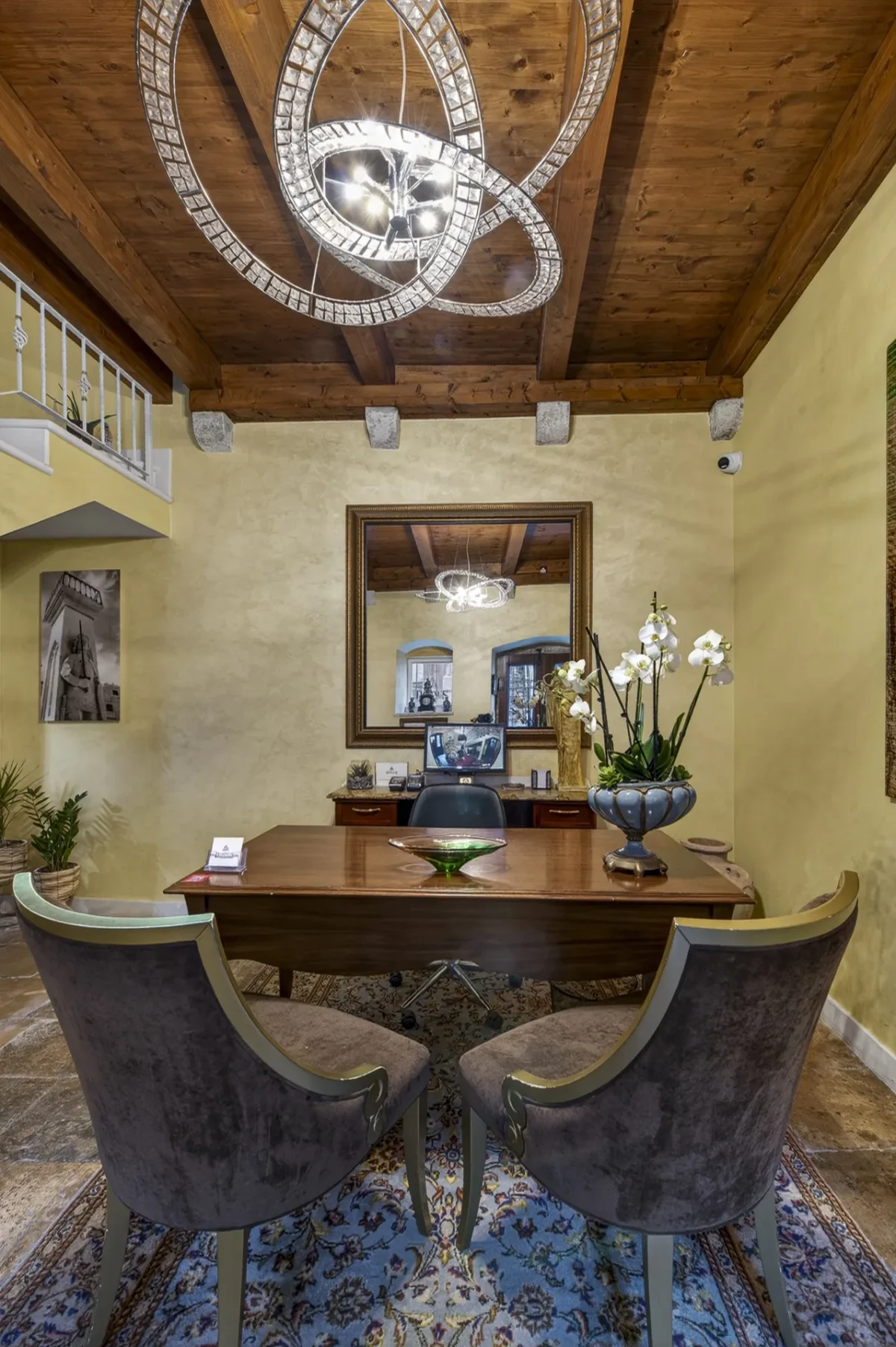 Crystal chandelier under wooden beams above the guest welcome desk at Dominus Little Palace in Dubrovnik