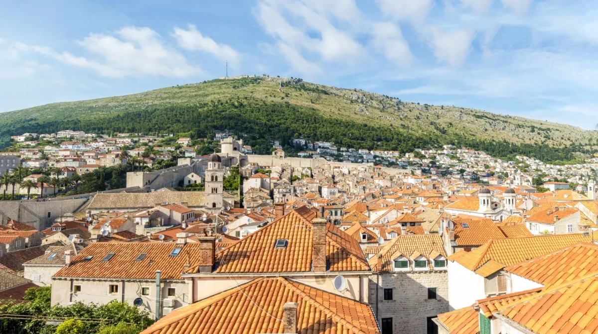 Panoramic view over Dubrovnik Old Town rooftops and city walls towards Mount Srđ
