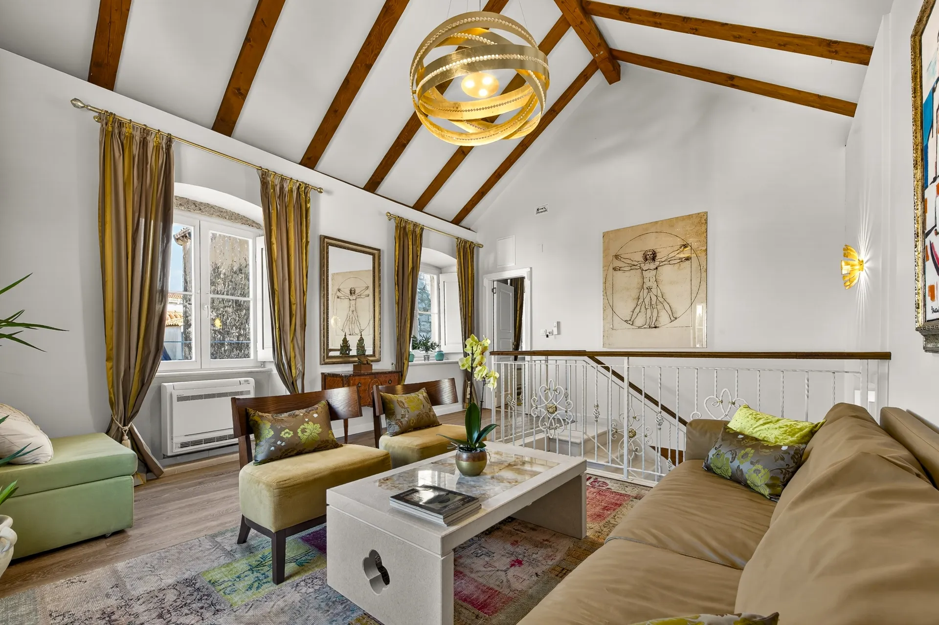 Executive Suite lounge with beamed attic ceiling, Vitruvian Man artwork and staircase railing
