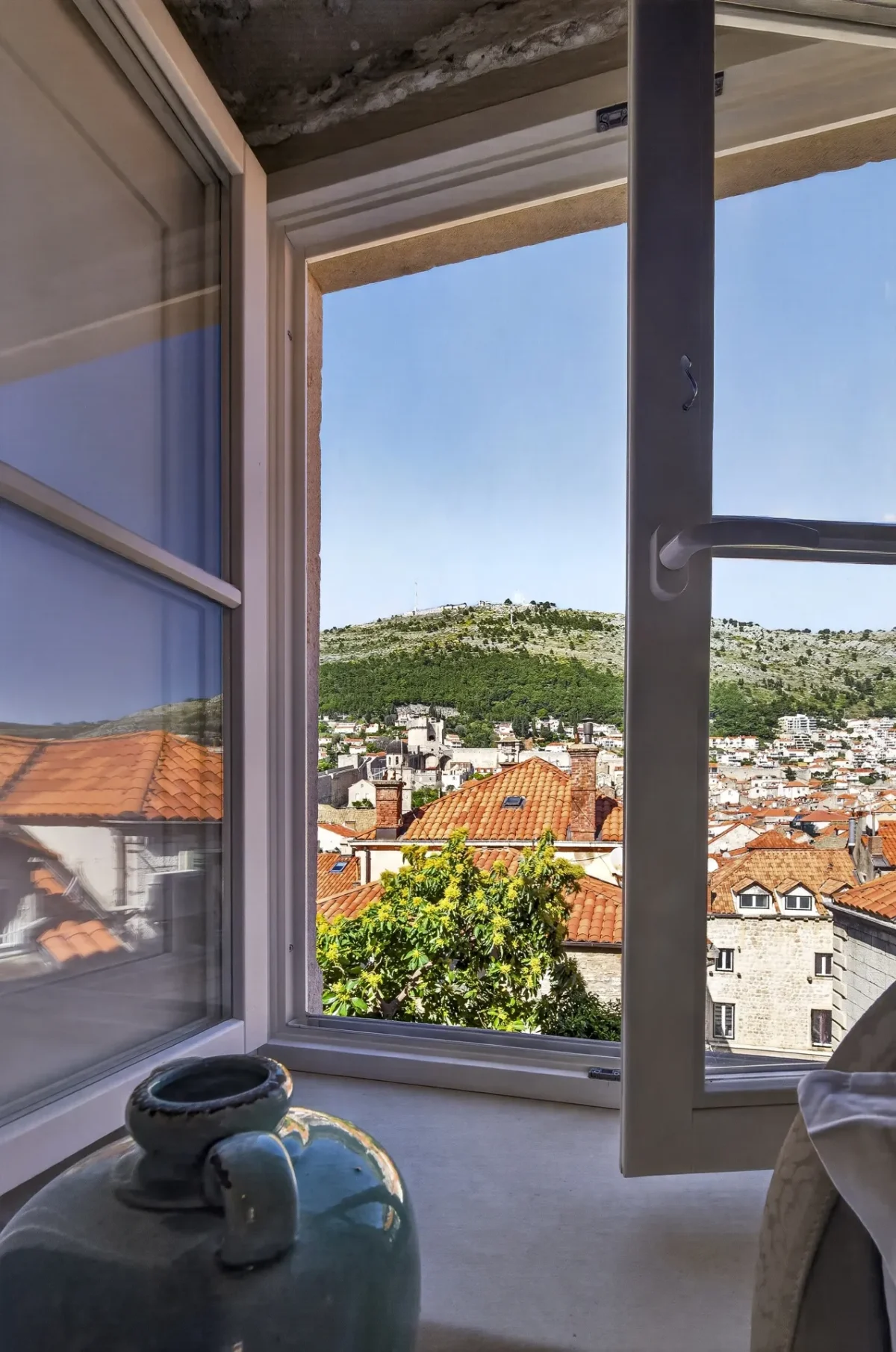 Open window in the Premium Double Room with views over Dubrovnik rooftops to Mount Srđ