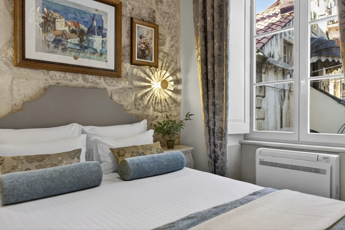 Premium Double bed with stone wall, Dubrovnik watercolour and open window onto an Old Town street
