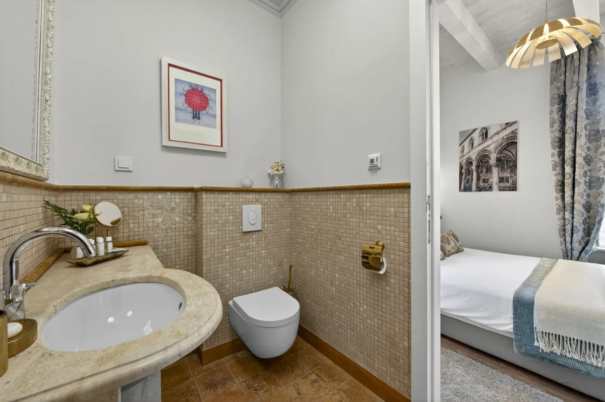 Premium Double bathroom with travertine washbasin and wall-hung toilet, open to the bedroom