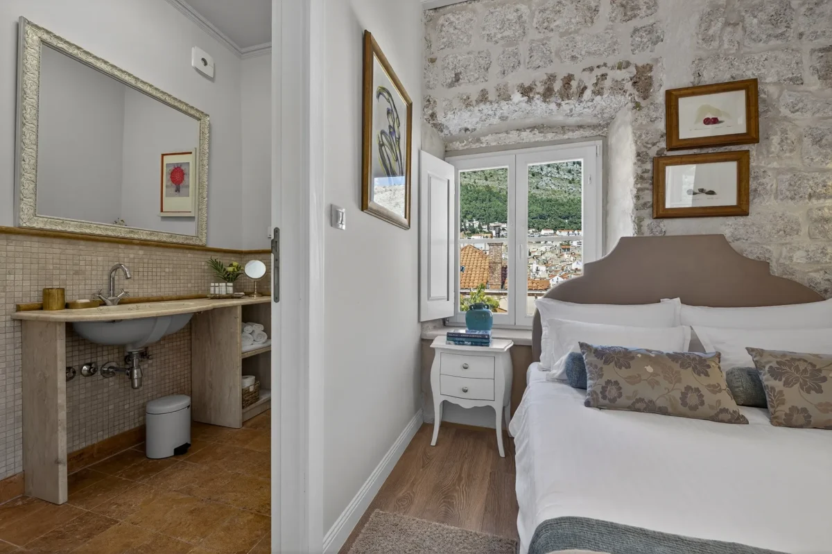 Premium Double Room with stone wall and window overlooking Dubrovnik, next to the en-suite bathroom